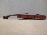 a violin sitting on a table with a white wall in the background