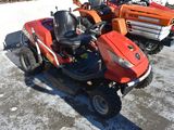 a picture of a red lawn mower parked in a parking lot