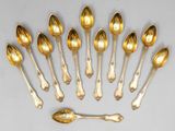 six cuillères et un repose-cuillère disposés en cercle sur une table