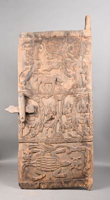 une vieille porte en bois ornée de sculptures représentant des animaux et des personnages