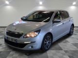 La voiture argentée est garée dans le showroom, sur le sol à damier.