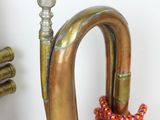 a brass trumpet that is next to a candle holder