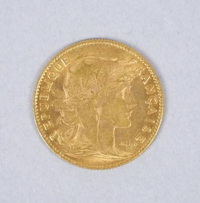 gros plan d'une pièce d'or sur une surface blanche
