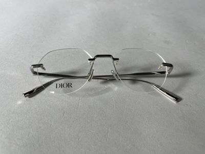 des lunettes posées sur une surface blanche sur laquelle est inscrit le mot « Dior »