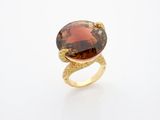 a gold ring with a large brown stone on top of it