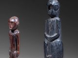 three carved wooden figures of a man and a woman