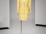 une photo d'un costume jaune sur un présentoir à mannequin