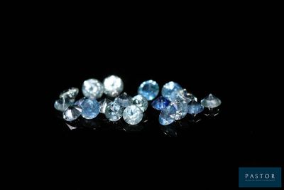 a close up of a bunch of blue diamonds on a black surface