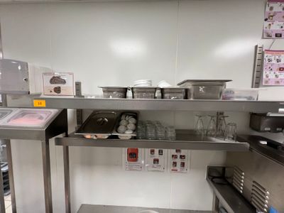 une cuisine équipée de plans de travail et d'une étagère en acier inoxydable