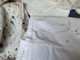 a bed that has a bunch of white linens on it