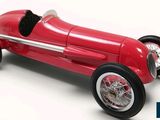 une image représentant une petite voiture de course rouge sur fond blanc