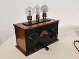 une boîte en bois surmontée de trois ampoules