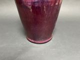 a purple vase sitting on a table in a room