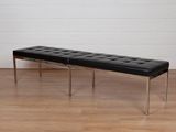 un banc noir posé sur un parquet dans une pièce