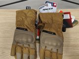 une paire de gants beiges posée sur une table en bois, avec un téléphone portable en arrière-plan