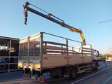a truck with a crane on the back driving down the street