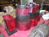 une table sur laquelle sont posés plusieurs vases rouges
