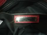 a close up of a black purse with a red tag on it