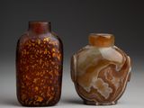 pair of brown and white vases sitting next to each other on a white surface
