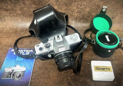 a camera and other items on the floor next to a book