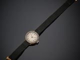 une vieille montre posée sur une surface noire, avec un fond noir