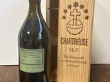 une bouteille de vin dans un coffret en bois, à côté d'une autre bouteille de vin