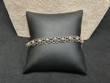 a black pillow with a chain around it on top of a pillow