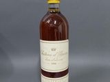 une bouteille de vin posée sur une table devant un fond gris