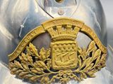 a silver helmet with a gold crest on it