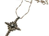 une photo d'un collier avec une croix suspendue à une chaîne