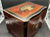 a small wooden box with a lion design on it