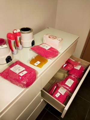 Plusieurs sachets de nourriture rose sont posés sur un plan de travail, à côté d'un mixeur