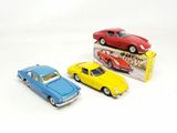 three toy cars sitting next to each other on a white surface