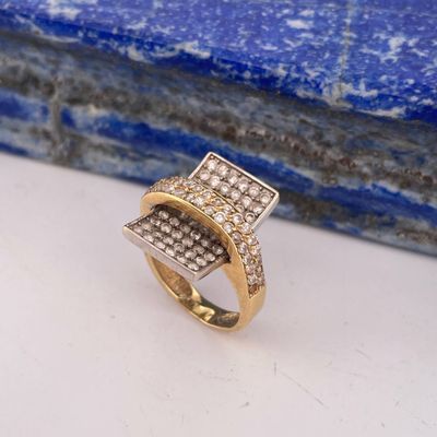 a close up of a gold and diamond ring on a blue stone