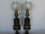 pair of antique oil lamps with glass globes on each of them