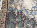 un tapis sur lequel sont représentés une femme et un cerf