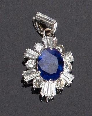 un gros plan d'un pendentif en saphir et diamants posé sur une surface noire