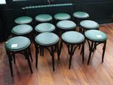 neuf tabourets posés sur un parquet devant une fenêtre