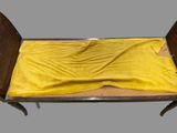 a bed with a yellow sheet on top of it