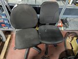 two black office chairs sitting on the floor in a room