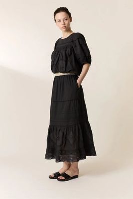 the woman is wearing a black dress and sandals