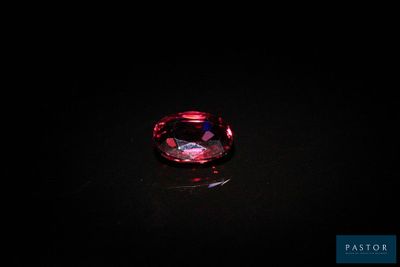 a close up of a red diamond on a black surface