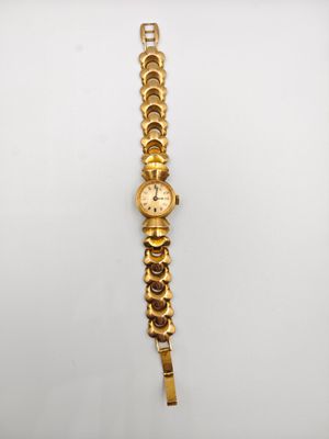 l'image d'une montre en or sur une surface blanche