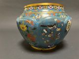 a blue vase with flowers and birds painted on it