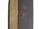an old book that is sitting on a white surface