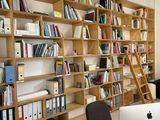 bookshelves and desks in an office with computers and bookshelves