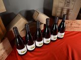 several bottles of wine are lined up on a red cloth