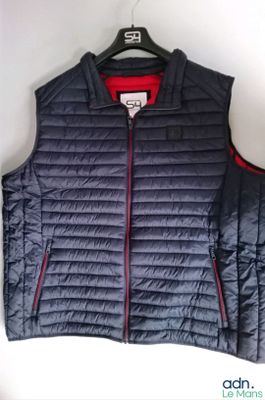 Le gilet est bleu et comporte une fermeture éclair rouge sur le devant.