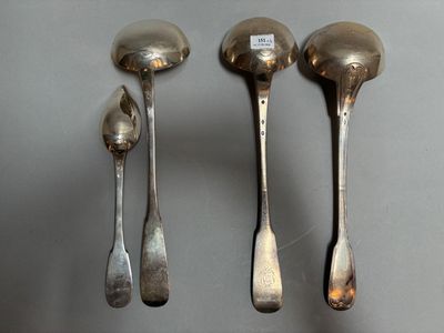 trois cuillères en argent et deux cuillères en argent sur une table