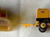 a yellow toy truck and a yellow toy truck